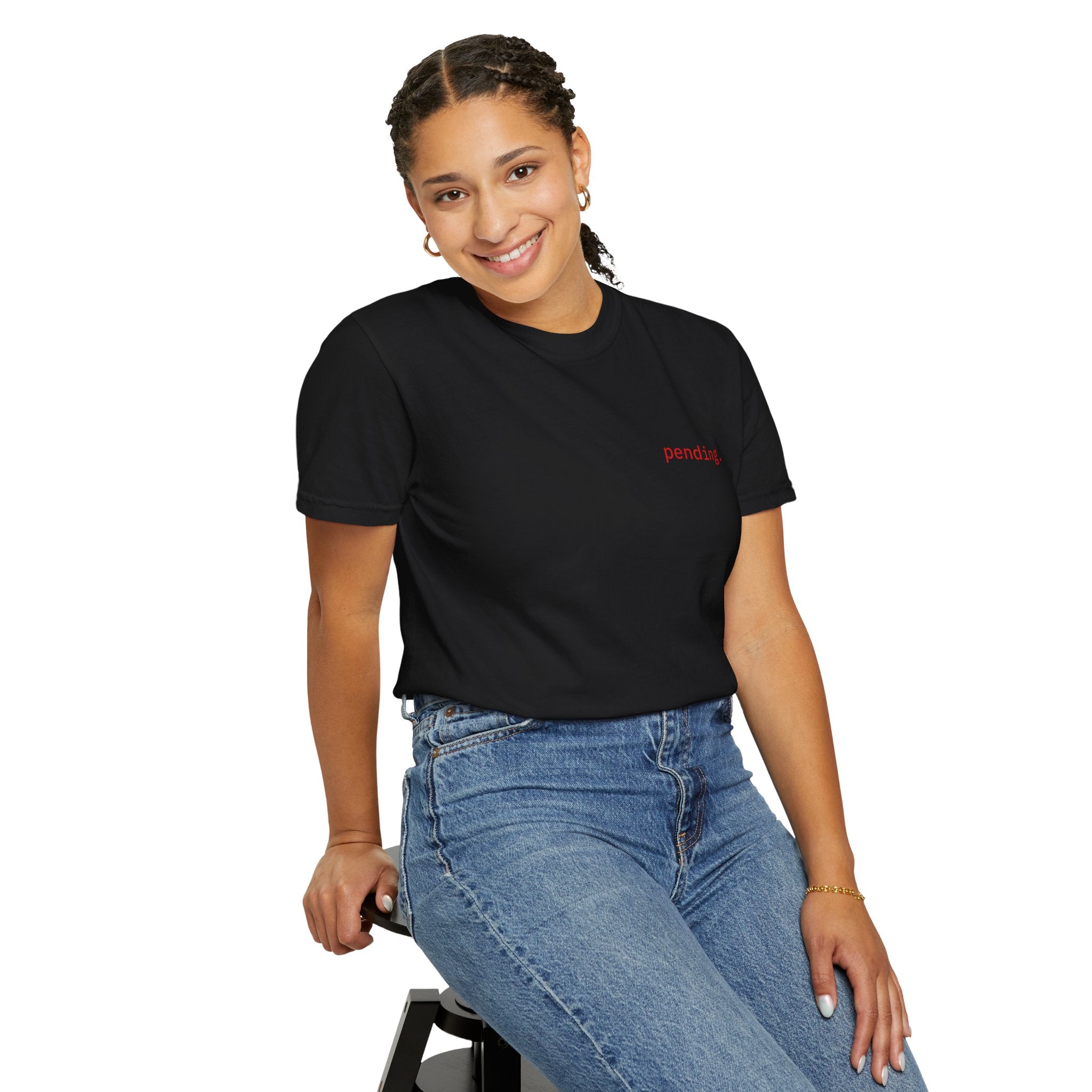 Person wearing a Black t-shirt and blue jeans sitting on a stool against a white background