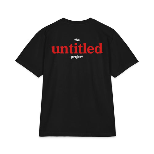 A Black short-sleeve t-shirt with a graphic print on the chest reading 'the untitled project' in red and white text, displayed against a solid white background.
