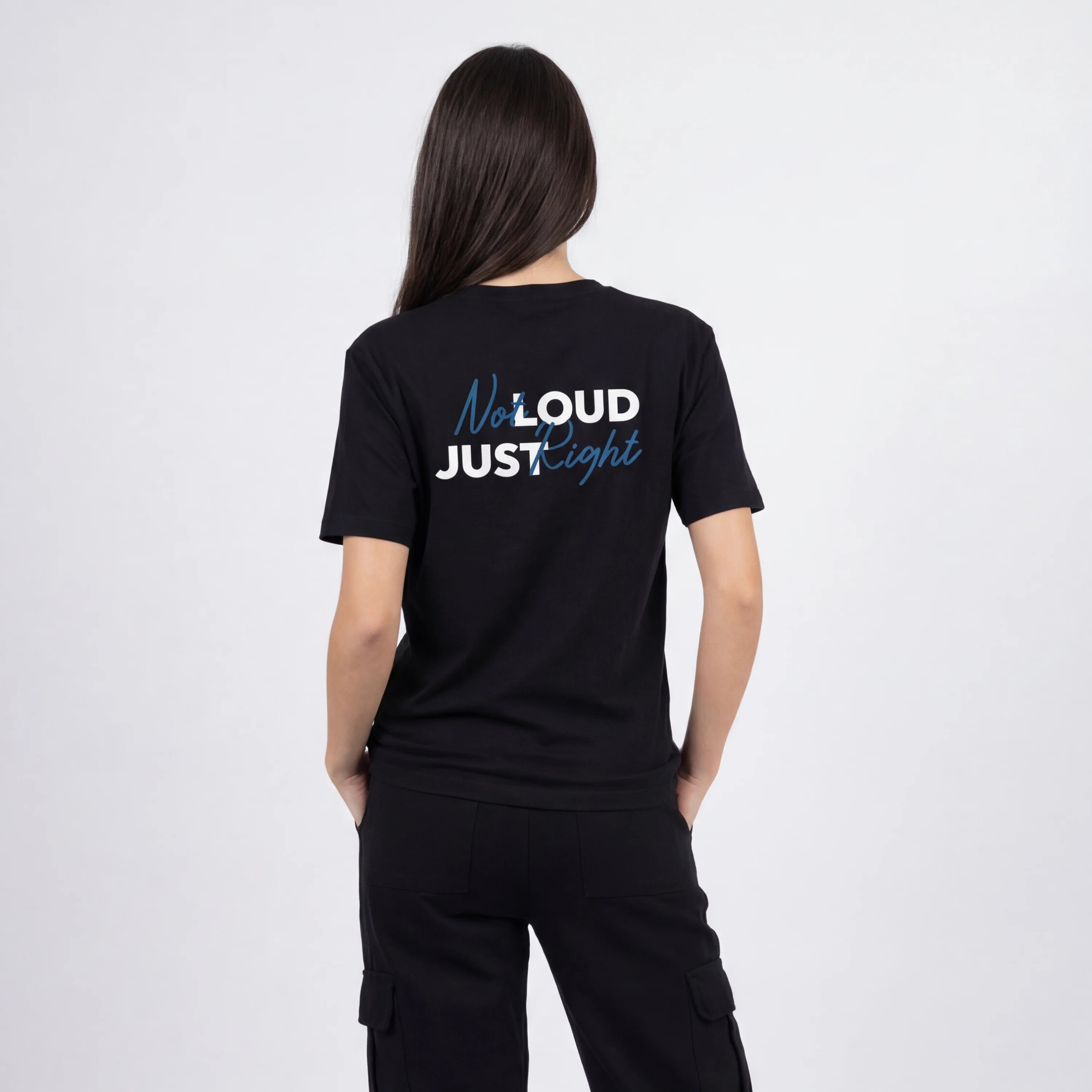 Person wearing a black t-shirt with text on the back against a white background