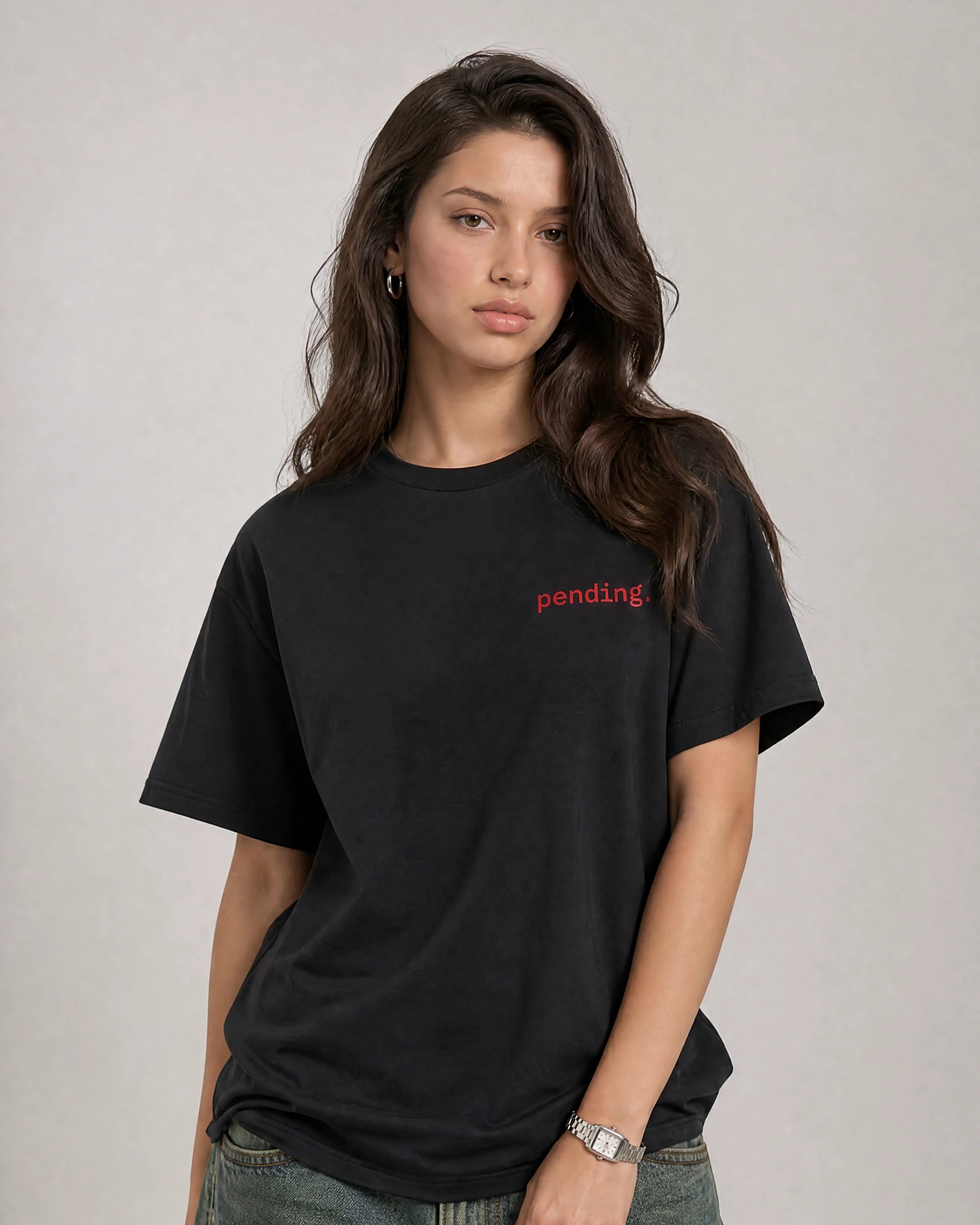 Person wearing a black t-shirt with 'pending' text on a plain background